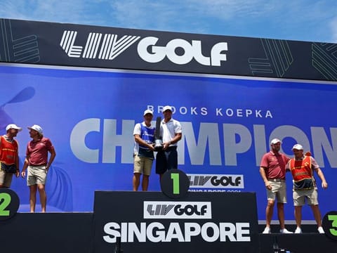 Smash GC's Brooks Koepka celebrates with the trophy on the podium after winning the LIV Golf Singapore.