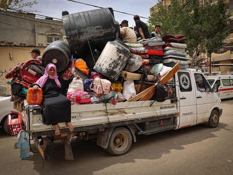 Palestinians pile their belongings on a vehicle as it drives to safer areas in Rafah, in the southern Gaza Strip, on May 10, 2024, amid the ongoing conflict between Israel and the militant group Hamas. 