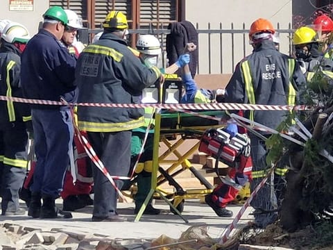 A man raises his hand as rescue workers carry him to an ambulance after being rescued, having survived 116 hours after a deadly building collapse in George, South Africa May 11, 2024. 
