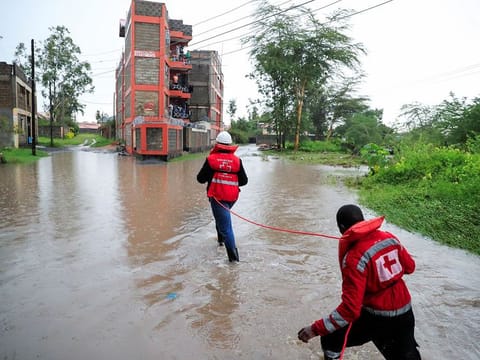 Kenya Red Cross members hold on to a safety rope as they wade through flood waters to assess and rescue residents trapped in their homes marooned after a seasonal river burst its banks following heavy rainfall in Kitengela municipality of Kajiado County, near Nairobi, Kenya May 1, 2024. 