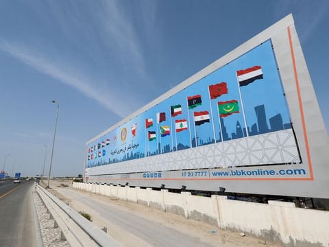 A billboard shows flags of countries participating in 33rd Arab Summit that will take place in Manama, Bahrain, May 14, 2024. 