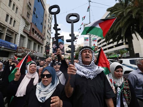 Palestinian protesters hold symbolic keys during a rally in the northern West Bank city of Nablus on May 15, 2024, marking the 76th anniversary of the "Nakba" or "Catastrophe" of the creation of Israel, which sparked the exodus of hundreds of thousands of Palestinians in 1948.  