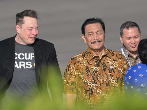 Tech billionaire Elon Musk (left) walks with Indonesia's Coordinating Minister of Maritime and Investment Affairs  Luhut Binsar Pandjaitan (centre) during his arrival at Ngurah Rai International airport in Denpasar on Indonesia's Bali island on May 19, 2024.