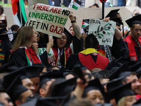 Graduating students hold a sign reading "There Are No Universities Left in Gaza" during the 373rd Commencement Exercises at Harvard University, amid the ongoing conflict between Israel and the Palestinian Islamist group Hamas, in Cambridge, Massachusetts, US, on May 23, 2024.   