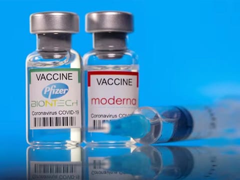 Vials with Pfizer-BioNTech and Moderna coronavirus disease (COVID-19) vaccine labels are seen in this illustration. 