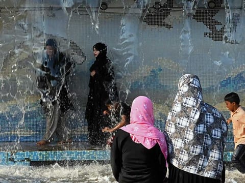 People cool themselves in a waterpark on a hot summer day in Hyderabad on May 23, 2024. India is no stranger to searing summer temperatures. But years of scientific research have found climate change is causing heatwaves to become longer, more frequent and more intense. 