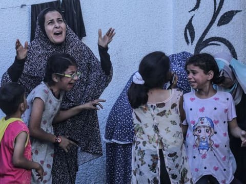  Palestinians react after an Israeli strike on a building in Nuseirat on May 25, 2024.