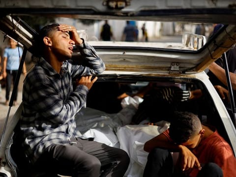 Mourners react next to the bodies of Palestinians killed in an Israeli strike on an area designated for displaced people, during their funeral in Rafah, in the southern Gaza Strip, May 27, 2024.  