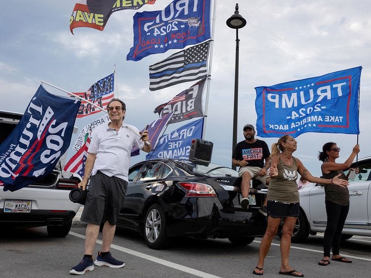 Supporters hold placards and flags 