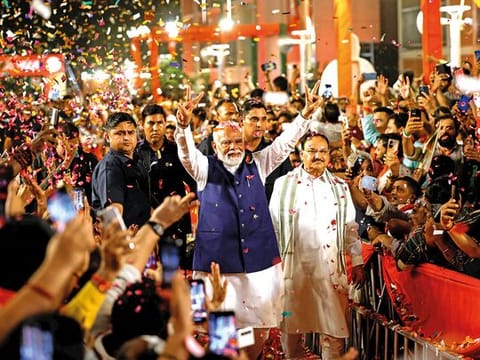 Supporters throw petals on Indian Prime Minister Narendra Modi as he arrives at Bharatiya Janata Party (BJP) headquarters in New Delhi on Tuesday.