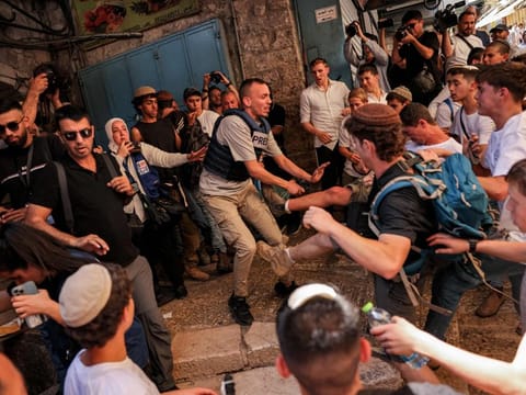 Israeli right-wing activists scuffle with a journalist during a march commemorating Jerusalem Day in the old city of Jerusalem on June 5, 2024. 