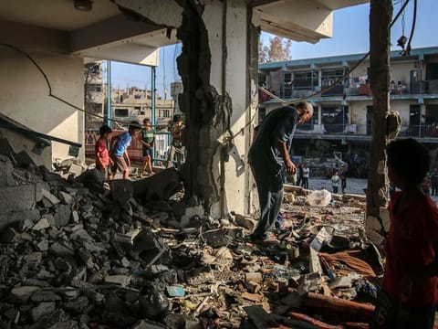 Palestinians inspect the damage to a school complex for displaced Palestinians, operated by the United Nations Relief and Works Agency (UNRWA), following an Israeli strike at the Nuseirat refugee camp in central Gaza, on Thursday, June 6, 2024. 