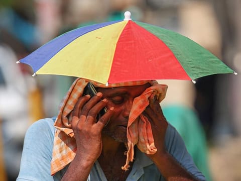 A vendor wipes his face with a cloth on a hot summer day in Varanasi on May 27, 2024.  