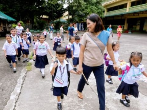 A Philippine public school teacher guides pupils during a school day. 