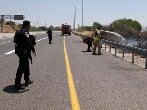 An Israeli firefighter douses a fire caused by rockets launched from southern Lebanon which landed on the outskirts of Amiad, in the upper Galilee, on June 12, 2024.  