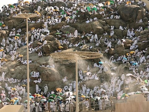 Mist dispensers refreshen pilgrims as they walk up Saudi Arabia's Mount Arafat, also known as Mount of Mercy, during the climax of the Hajj pilgrimage on June 15, 2024. 