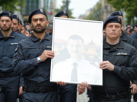German police officers carry an image of their colleague Rouven Laur who got killed following a knife attack by an Afghan asylum seeker at a far right-wing information stand at the central market of the city of Mannheim on May 31, in Mannheim, June 14, 2024.  