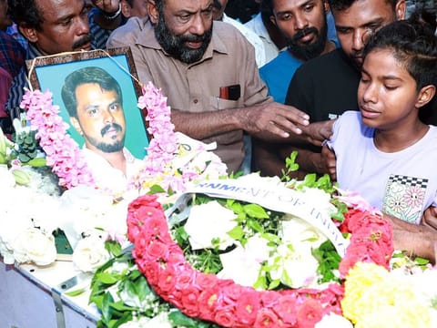 Ashtami , daughter of Arun Babu who lost his life in the Kuwait fire tragedy, near his father's mortal remains, in Thiruvananthapuram.