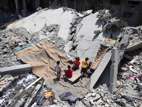 Palestinians children play on the site of a destroyed building in the Nuseirat refugee camp, in the central Gaza Strip on June 15, 2024, amid the ongoing conflict between Israel and the Palestinian Hamas militant group.  