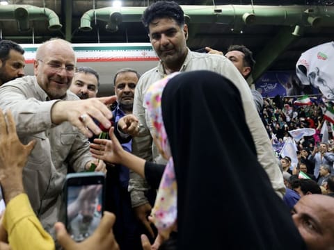 Iran's conservative Parliament Speaker Mohammad Bagher Ghalibaf reaches out to a female supporter during an election campaign ahead of a presidential vote to replace the late president, in the Iranian capital Tehran on June 26, 2024.  
