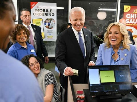 US President Joe Biden (C) and US First Lady Jill Biden make a purchase as they visit a Waffle House in Marietta, Georgia, after Biden participated in the first presidential debate of the 2024 elections, on June 27, 2024.  