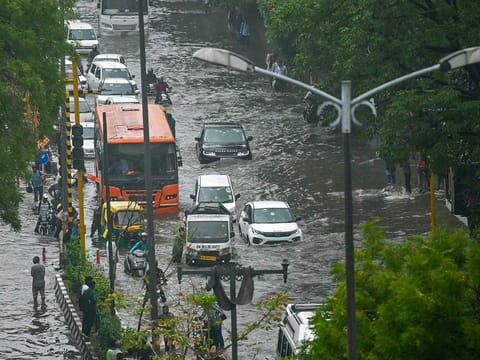 Vehicles make their way through flooded streets after heavy rains in New Delhi on June 28, 2024. 