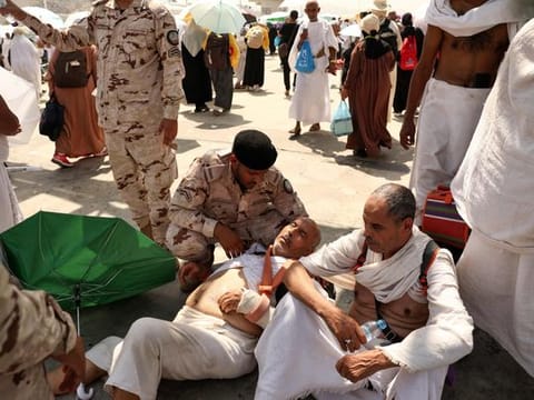 A man effected by the scorching heat is helped by a member of the Saudi security forces as pilgrims arrive to perform the symbolic 'stoning of the devil' ritual as part of the pilgrimage in Mina, near Mecca, on June 16, 2024.  