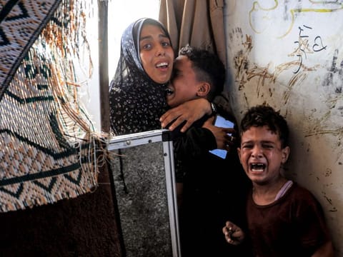 A family reacts after Israeli bombardment as they take refuge at the Jaouni school run by the UN Relief and Works Agency for Palestine Refugees (UNRWA) in Nuseirat in the central Gaza Strip on July 6, 2024 amid the ongoing conflict in the Palestinian territory between Israel and Hamas. (Photo by Eyad BABA / AFP)
