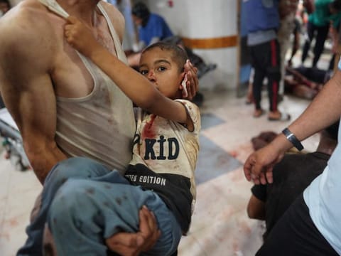 A man carries a child injured in Israeli bombardment upon his arrival at Nasser hospital in Khan Younis in the southern Gaza Strip on July 9, 2024.