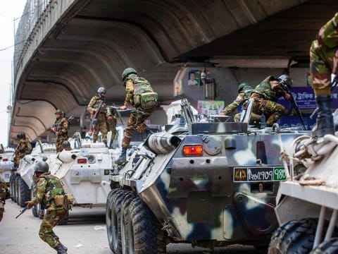 Bangladeshi soldiers disembark armoured vehicles as they patrol the streets to disperse the anti-quota protesters in Dhaka on July 20, 2024.  