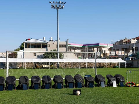 Chairs covered in black representing 12 members of the Druze community killed in a rocket strike from Lebanon, are lined up in the football pitch where the attack took place, during their funeral in the Druze town of Majdal Shams in the Israel-annexed Golan Heights, on July 28, 2024.  