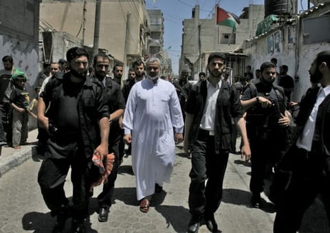 File photo shows Ismail Haniyeh walking through the streets of Gaza City's Al Shati refugee camp after attending the weekly Friday prayers.