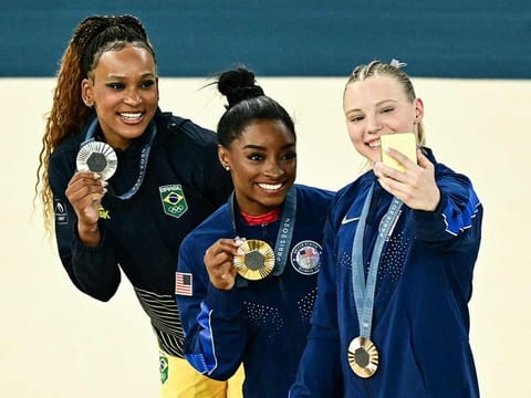 From left: Brazil's Rebeca Andrade (silver), US' Simone Biles (gold) and US' Jade Carey (bronze) take a selfie during the podium ceremony for the artistic gymnastics women's vault during the Paris 2024 Olympic Games at the Bercy Arena in Paris, on August 3, 2024. 