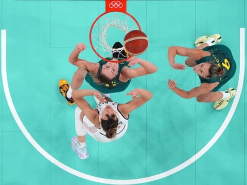 An overview shows (Clockwise from bottom left) Serbia's Tina Krajisnik, Australia's Alanna Smith and Steph Talbot eye a rebound in the women's quarterfinal basketball match during the Paris 2024 Olympic Games at the Bercy  Arena in Paris yesterday.