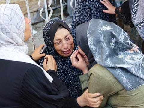 A woman reacts after identifying a member of her family among the dead at the Al Maamadani hospital, following an Israeli strike that killed more than 90 people on a school sheltering displaced Palestinians in Gaza City on August 10, 2024. 