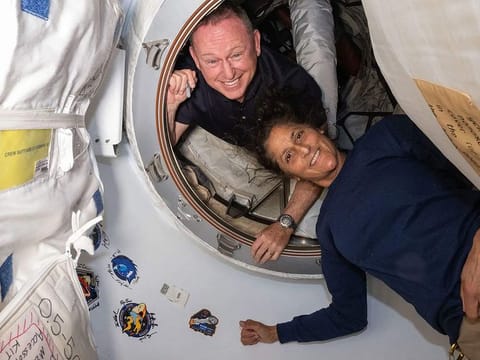 This undated handout picture from Nasa released on July 2, 2024 shows NASA’s Boeing Crew Flight Test astronauts (from top) Butch Wilmore and Suni Williams inside the vestibule between the forward port on the International Space Station’s Harmony module and Boeing's Starliner spacecraft. 
