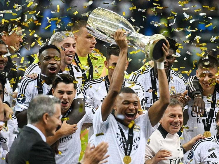 Real Madrid's French forward Kylian Mbappe celebrates with the trophy