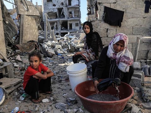 Amal Al Robayaa, washes clothes amid the ruins of the family home destroyed in an Israeli strike in Rafah in the southern Gaza Strip.
