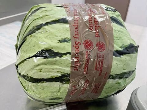 A package wrapped in paper and made to look like a watermelon. 