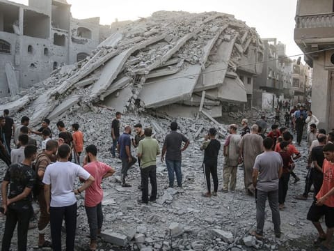 Palestinians inspect the damage to buildings following an Israeli raid on the Zaqout Tower in the Nuseirat refugee camp, in central Gaza, on Thursday, Aug. 22, 2024.  