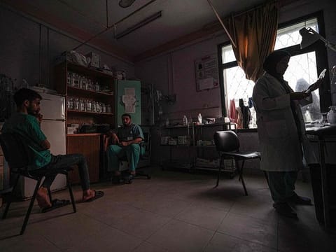 Medics gather in a room lit by sunlight seeping through a window, after a partial power cut at the Al Aqsa Martyrs Hospital in Deir Al Balah, amid continuing battles between Israel and Hamas in the Gaza Strip. 