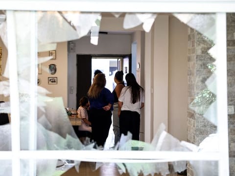 Residents check the damage caused by a strike from Lebanon in the Israeli coastal town of Acre on August 25, 2024.  