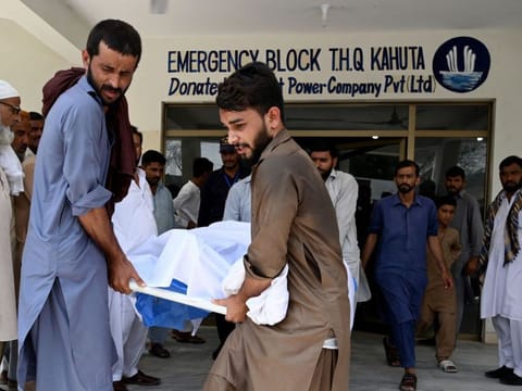 People move the body of a bus accident victim from a hospial in Kahuta, Punjab province, on August 25, 2024.  
