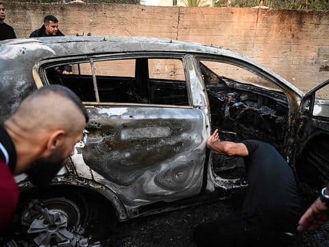 People check a burnt car in the small town of Zababdeh, southeast of Jenin in the occupied West Bank on August 30, 2024, following an Israeli army raid. 