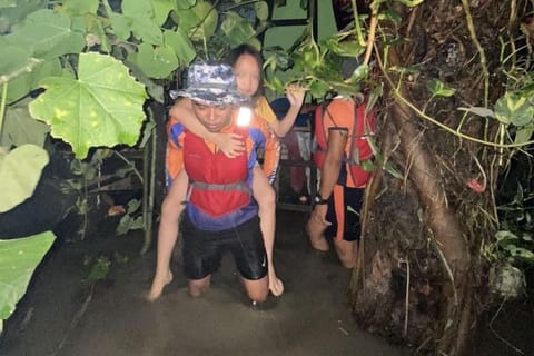 This handout photo taken and received from the Philippine Coast Guard (PCG) on September 2, 2024 shows rescue workers helping residents following flooding brought by Tropical Storm Yagi at Bacoor.  