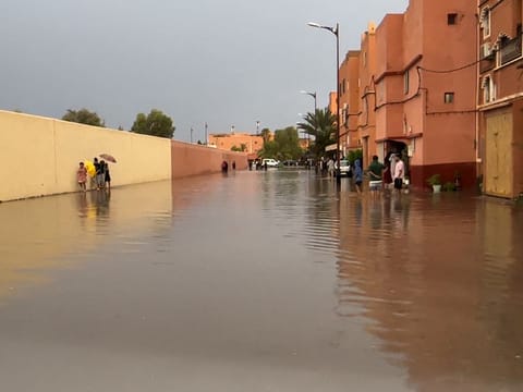 Residents walk on a flooded street in Morocco's Ouarzazate city on September 7, 2024. 