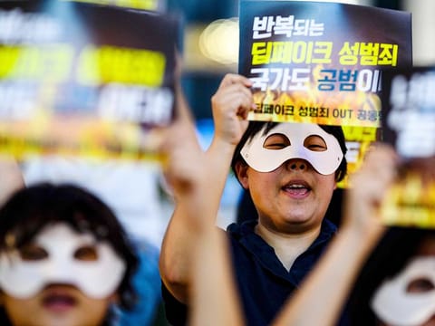 Activists wearing eye masks, hold posters reading ‘Repeated deepfake sex crimes, the state is an accomplice too’ during a protest against deepfake porn in Seoul on August 30, 2024. 