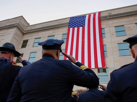 Members of the military and first responders watch as an American flag is unfurled on the side of the Pentagon to commemorate the 23rd anniversary of the 9/11 terror attacks on September 11, 2024 in Arlington, Virginia. Later today U.S. President Joe Biden and U.S. Vice President Kamala Harris will visit the Pentagon to lay a wreath to honor the victims of the September 11th terror attack.   