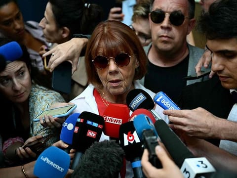 Gisele P. (C), escorted by her lawyer Stephane Babonneau (R) and one of her sons David (2ndR), addresses media as she leaves the courthouse during the trial of her husband accused of drugging her for nearly ten years and inviting strangers to rape her at their home in Mazan, a small town in the south of France, in Avignon, on September 5, 2024.  