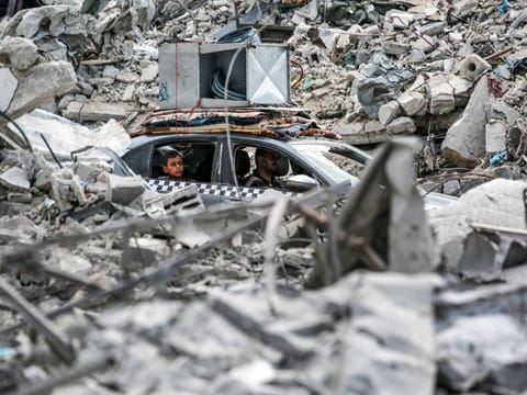 A vehicle moves past the rubble of collapsed buildings in Khan Yunis in the southern Gaza Strip on September 16, 2024, amid the ongoing war in the Palestinian territory between Israel and Hamas.